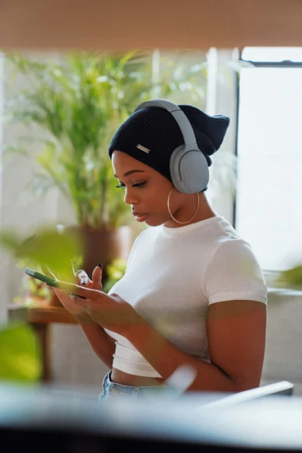 A woman wearing headphones and using an app.