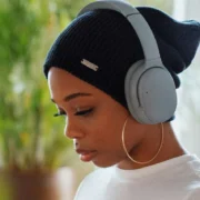 A woman wearing headphones and using an app.