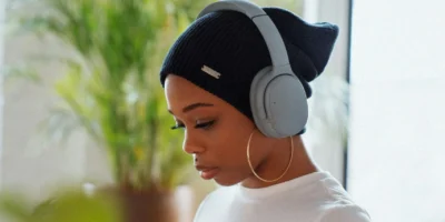 A woman wearing headphones and using an app.