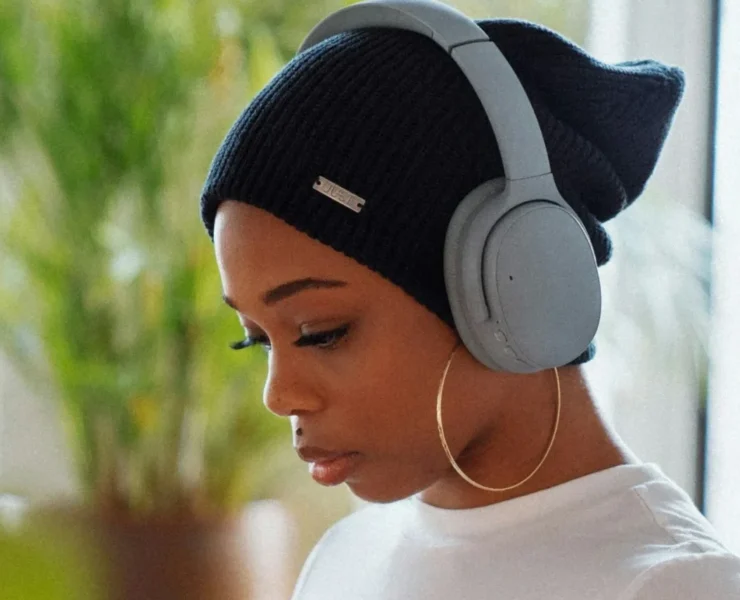 A woman wearing headphones and using an app.