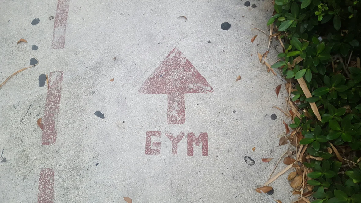 A sidewalk with "GYM" spray painted and an arrow.