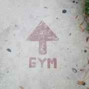 A sidewalk with "GYM" spray painted and an arrow.