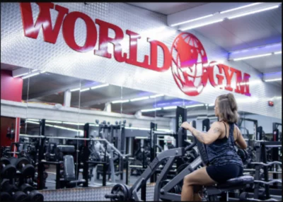 A woman strength training inside a World Gym.