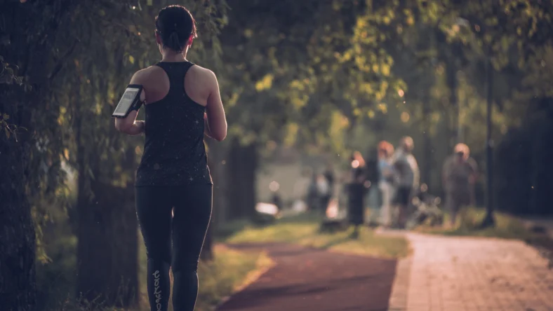 A woman running on a trail.