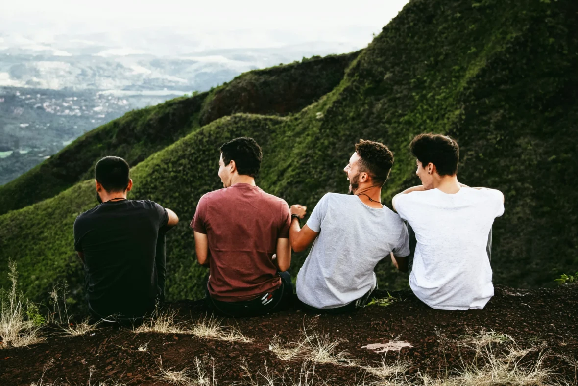 Four men enjoying the view on a hill.