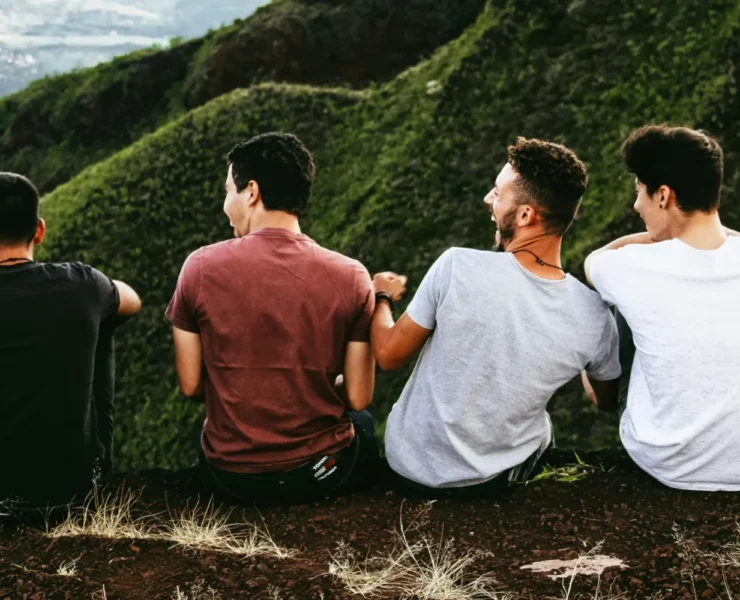 Four men enjoying the view on a hill.