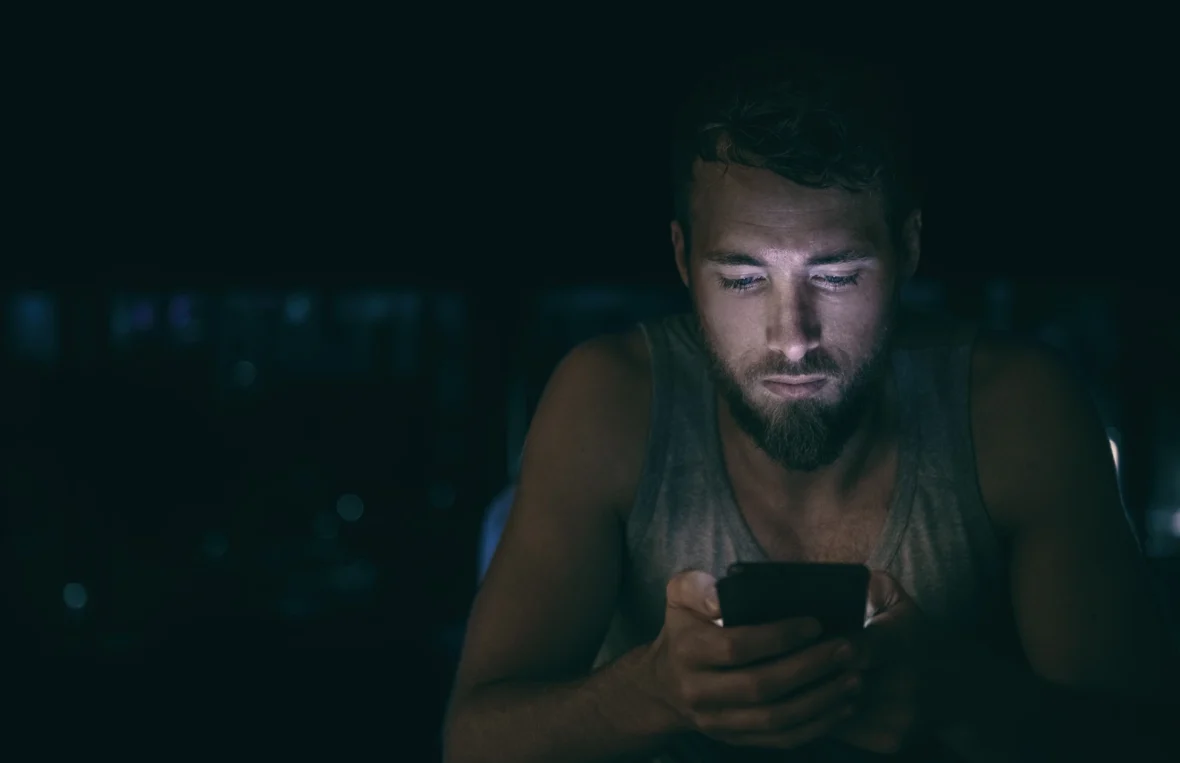 anxious young man doom-scrolls on his phone