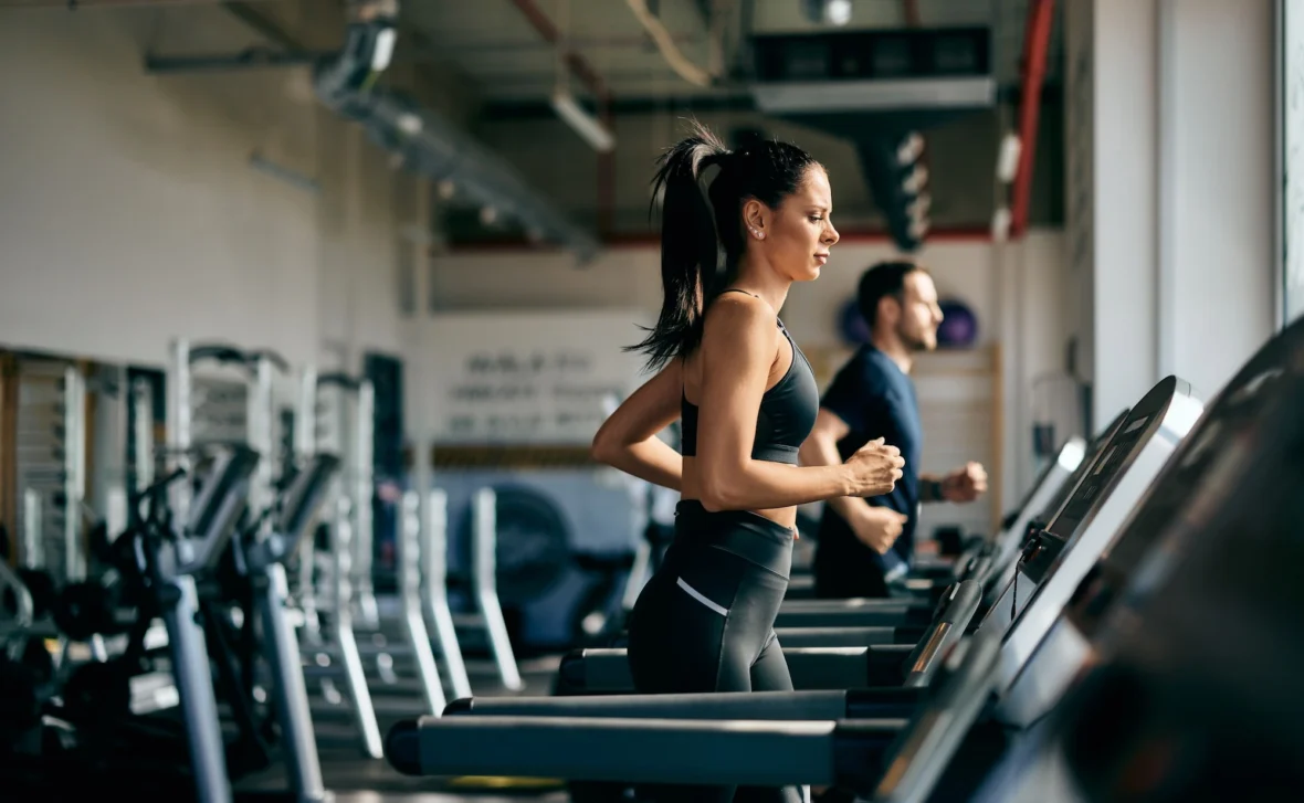 woman runs on the treadmill inside a gym