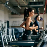 woman runs on the treadmill inside a gym