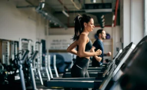 woman runs on the treadmill inside a gym