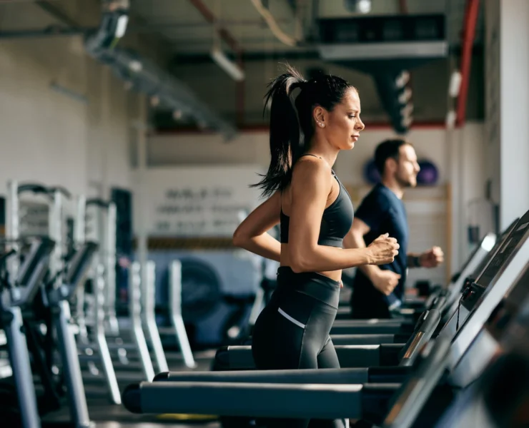 woman runs on the treadmill inside a gym