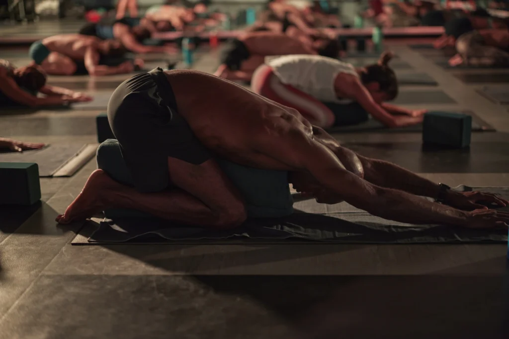 people perform yoga poses in a heated studio