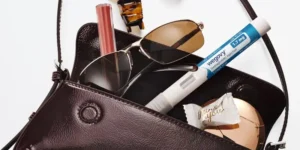 A woman's bag with items in it, including a GLP-1 shot.