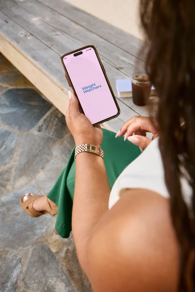 A woman looks at her WW app.