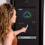 woman touches the screen on the Tonal 2 machine