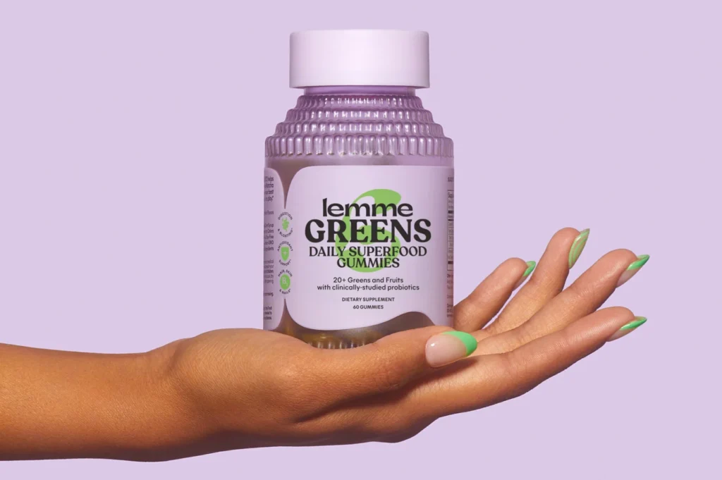 A hand holding a jar of Lemme Greens.