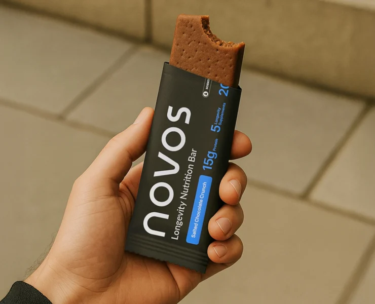 man holds a Novos chocolate functional longevity bar