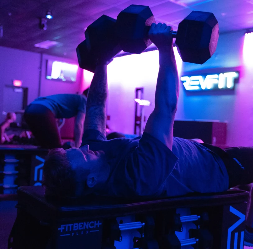 a man lifting weights at RevFit
