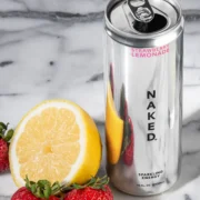 a can of Naked Sparking Energy alongside a lemon and strawberries.