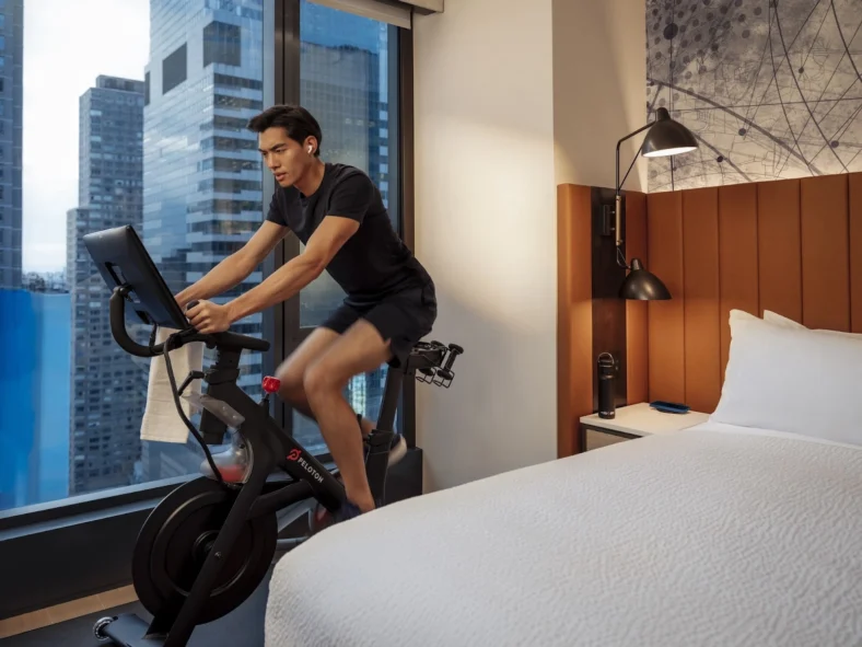 man uses a Peloton inside a Hyatt hotel room