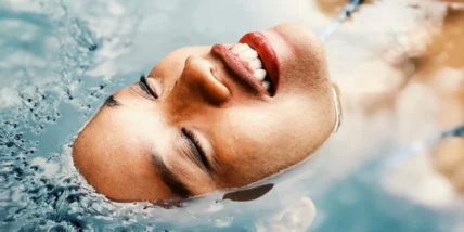 A woman relaxing in a pool of water.