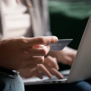 man enters his credit card info on a laptop