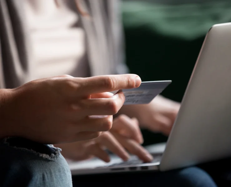 man enters his credit card info on a laptop