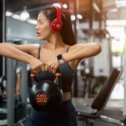 woman work out with a kettlebell and headphones on