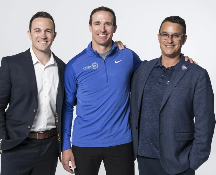 Drew Brees poses with Stretch Zone's Tony Zaccario and Jorden Gold