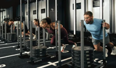 people push weight sleds inside a Hyrox training facility
