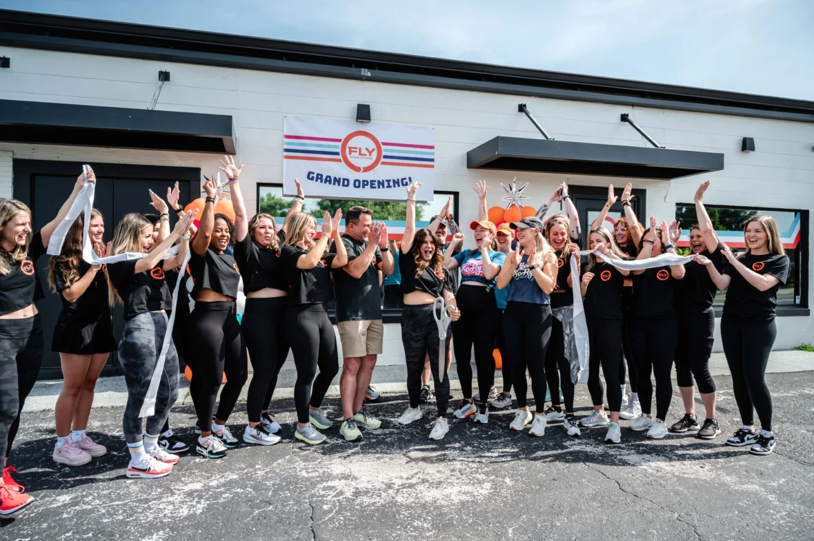 people pose for a photo outside of a Fly Dance Fitness location