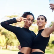 two young women in fitness gear pose for a selfie