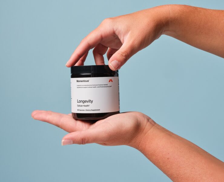 hands hold a Momentous longevity supplement case