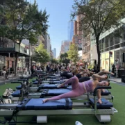 people work out on Pilates reformers outside