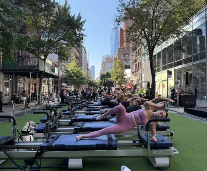 people work out on Pilates reformers outside