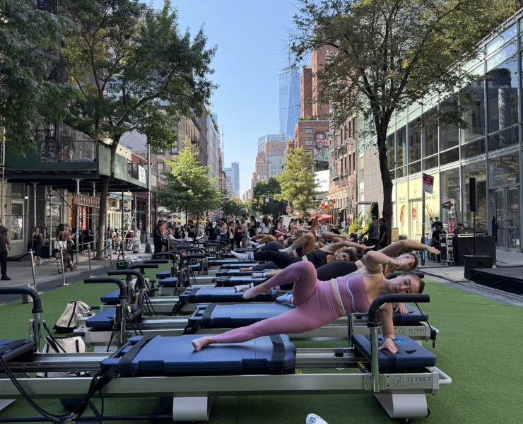 people work out on Pilates reformers outside