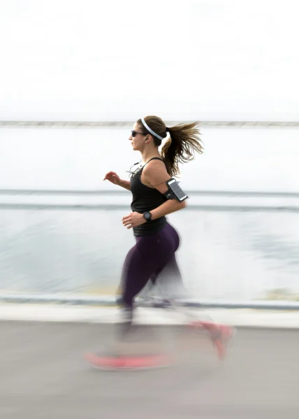 a woman running with a wearable watch on her wrist.