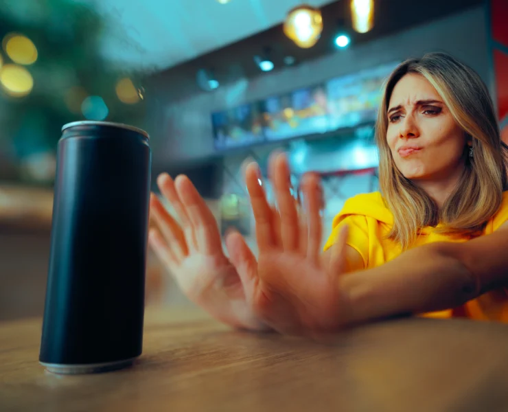 woman pushes away a can of liquid