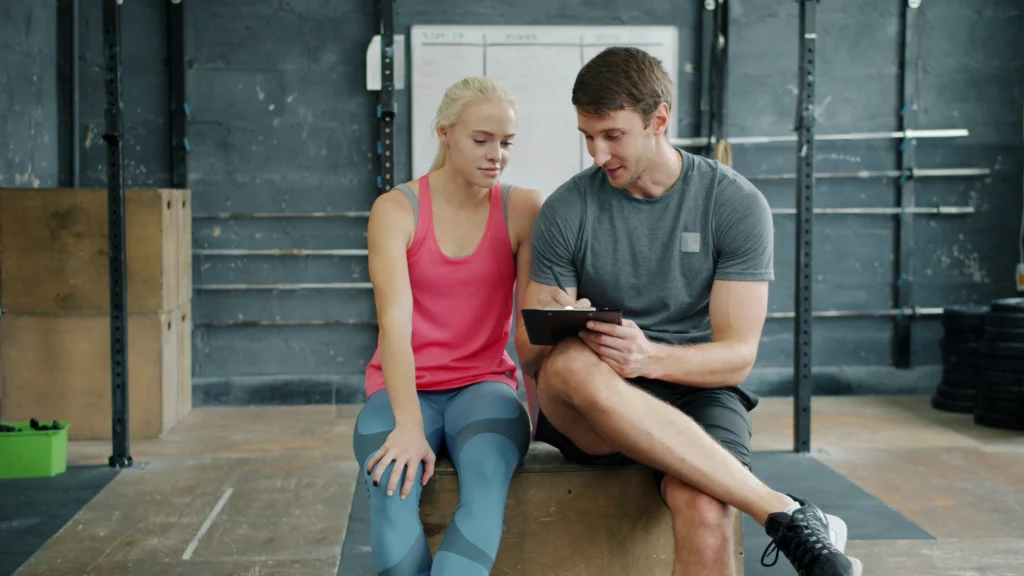 personal trainer gives a client fitness advice