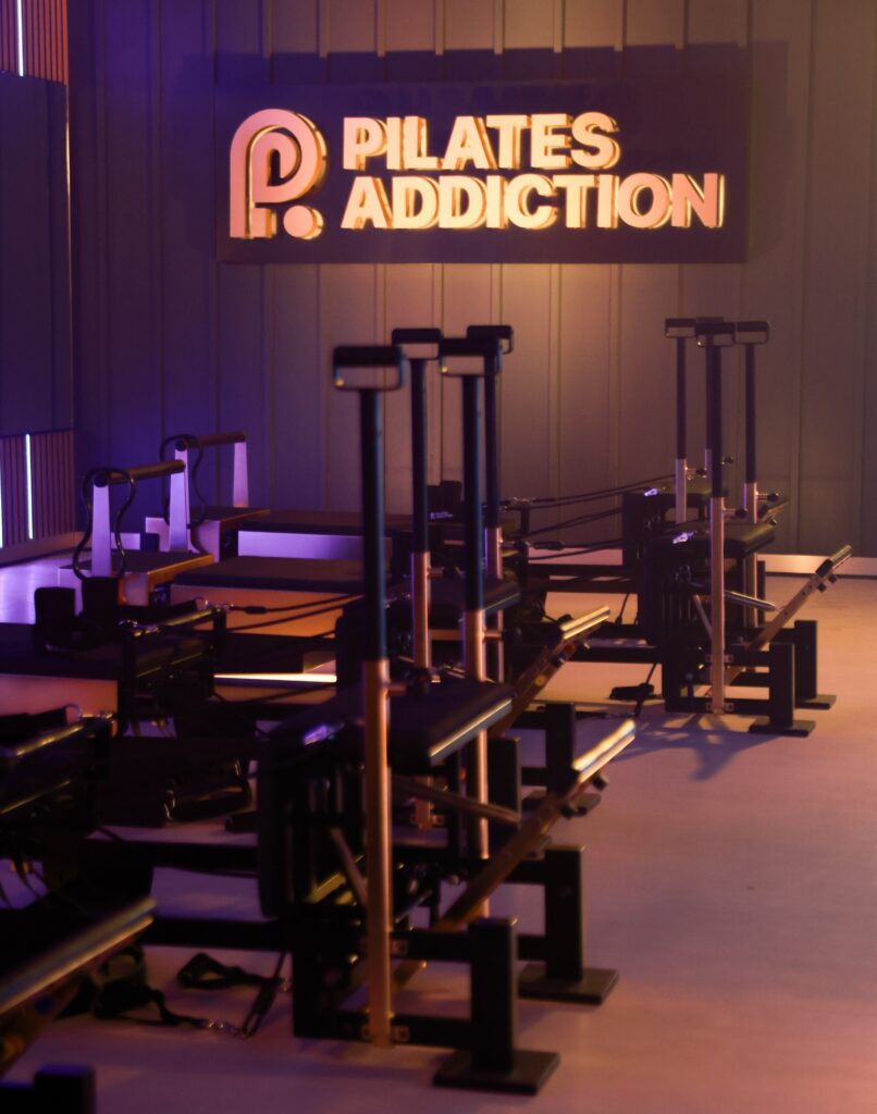 Pilates addiction sign and reformers inside a studio