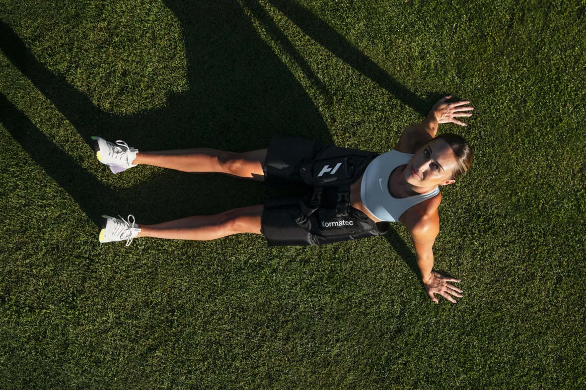 woman wears the Normatec Hip device