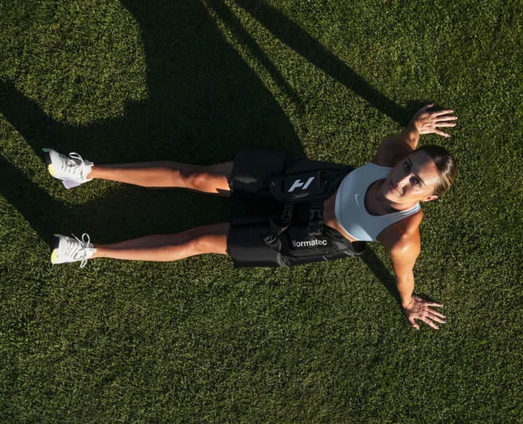 woman wears the Normatec Hip device