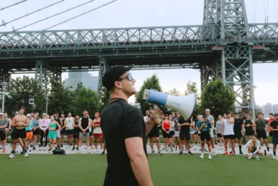 man holds a megaphone near a bridge in New York City