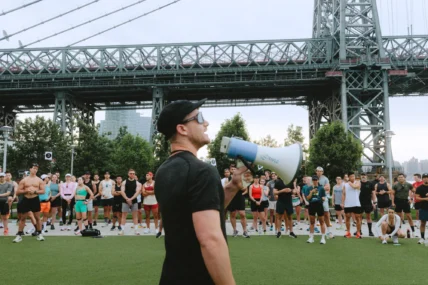 man holds a megaphone near a bridge in New York City