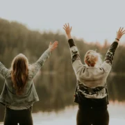 women in front of a lake