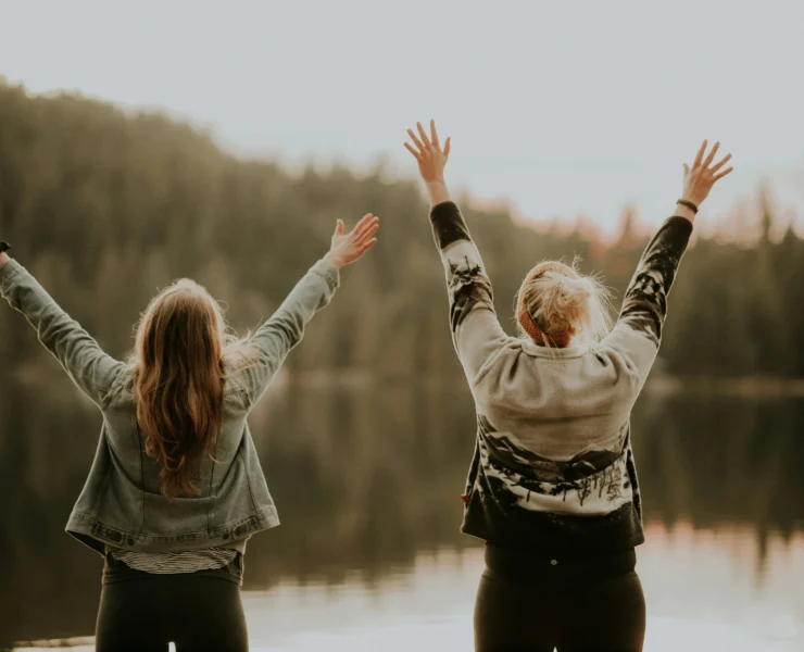 women in front of a lake