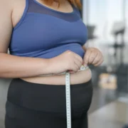 overweight woman measures her waist