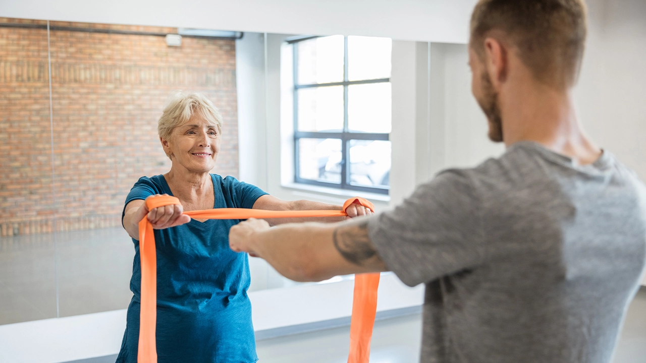 elderly woman works out with a personal trainer