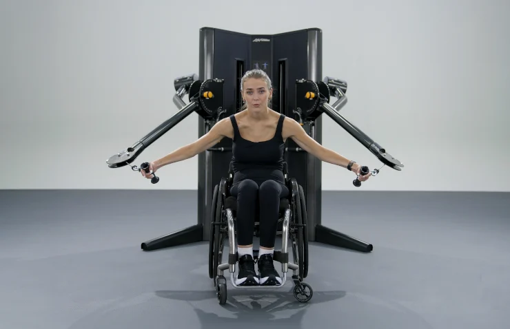woman in a wheelchair works out with the new Life Fitness cable machine