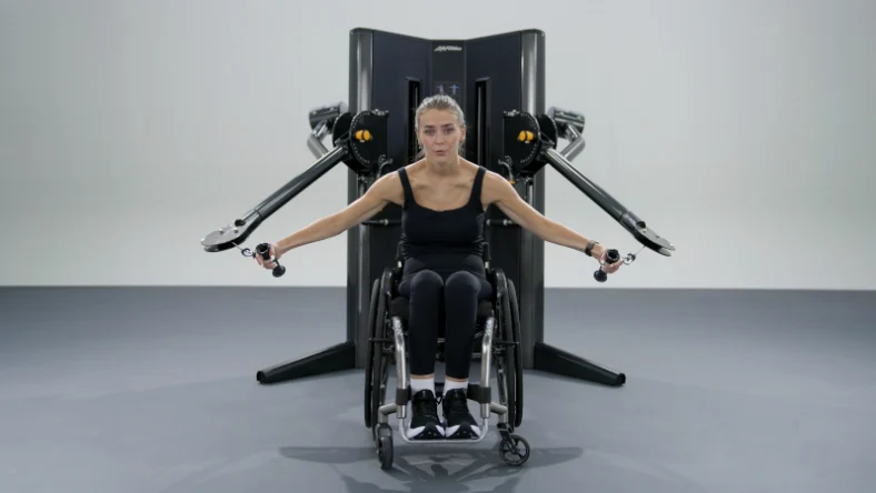 woman in a wheelchair works out with the new Life Fitness cable machine
